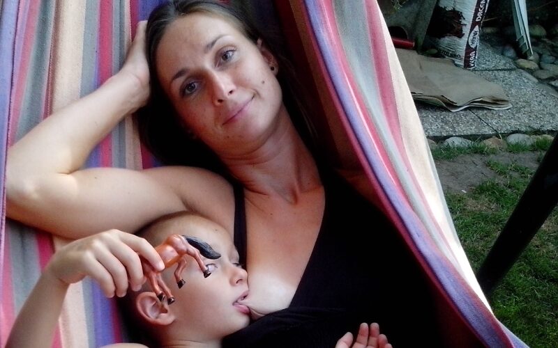 Matka v hojdacej sieti dojčí svoje dieťa